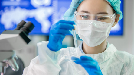 Scientist holding pipette.