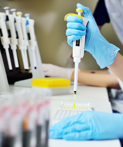 Scientist in a medical laboratory with a dispenser in their hands doing an analysis