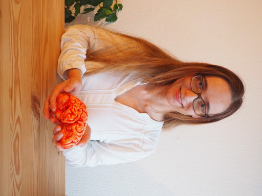 Female scientist with glasses displaying chocolate brain.